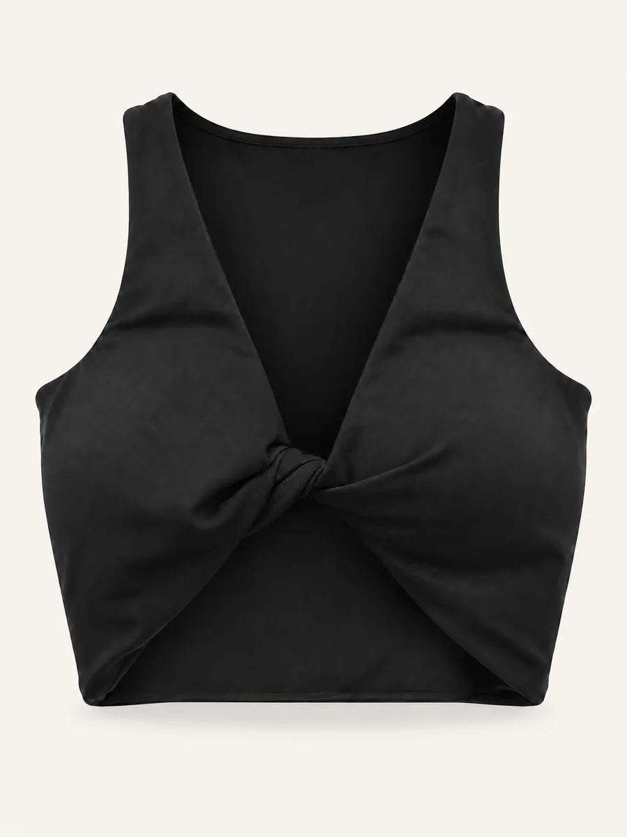 Black crossover crop top with front knot on a warm off-white background