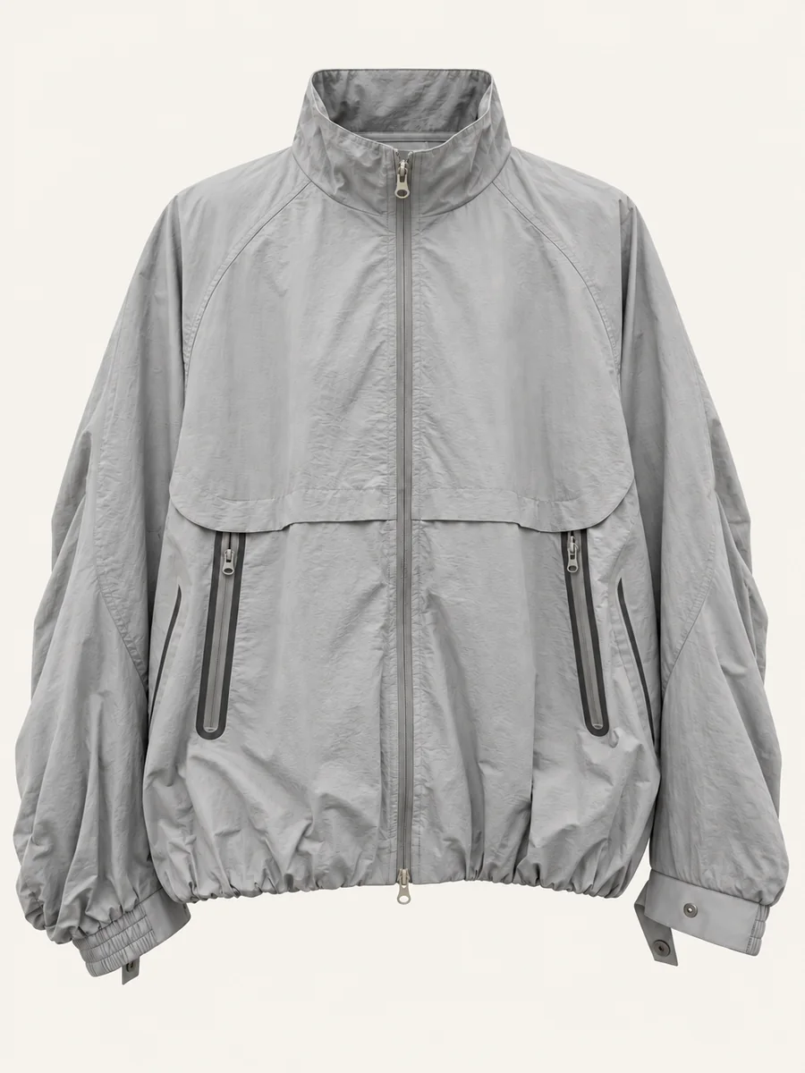 Light gray technical windbreaker jacket on a warm off-white background